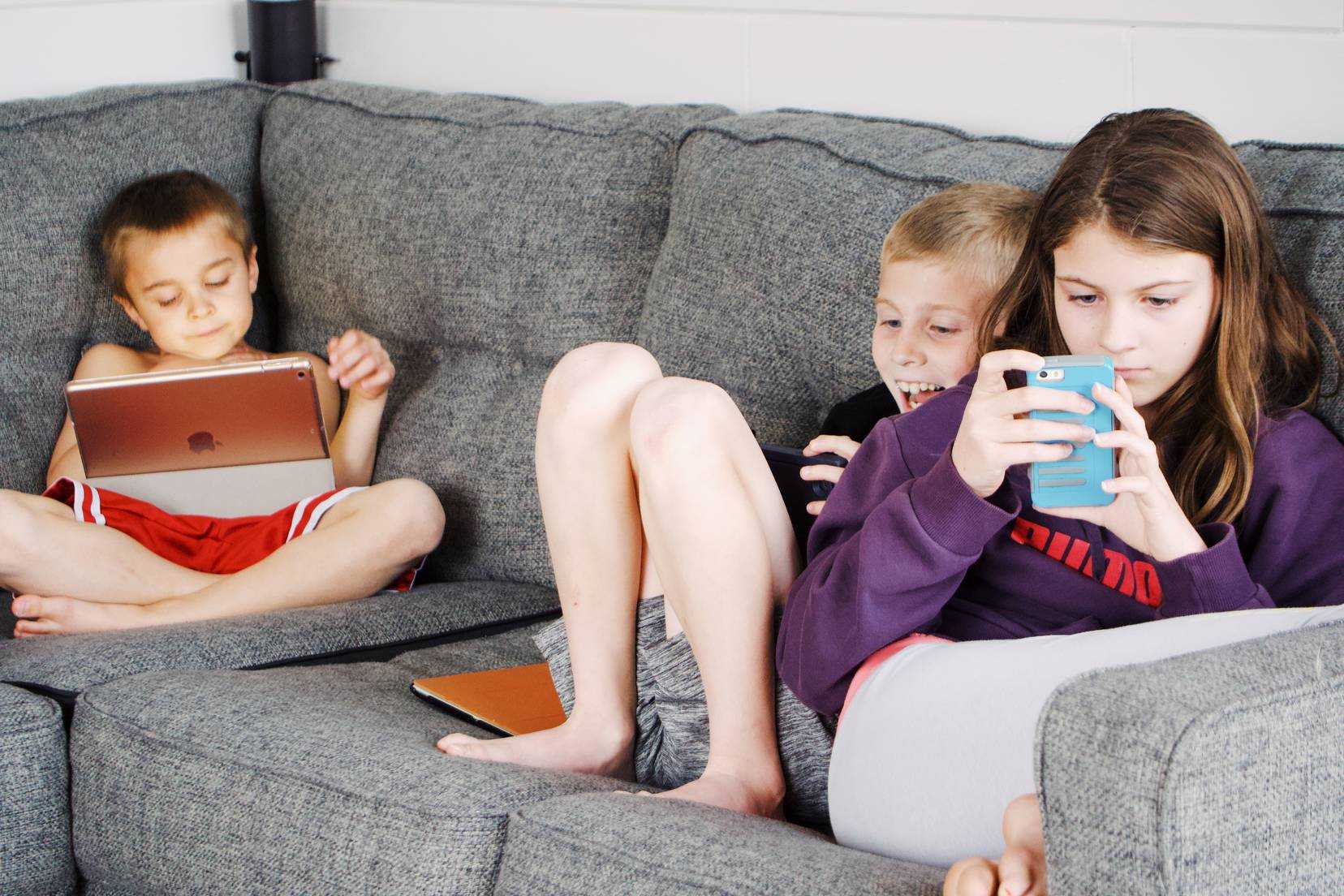 Kids are busy watching mobile. Image courtesy: pexels.com